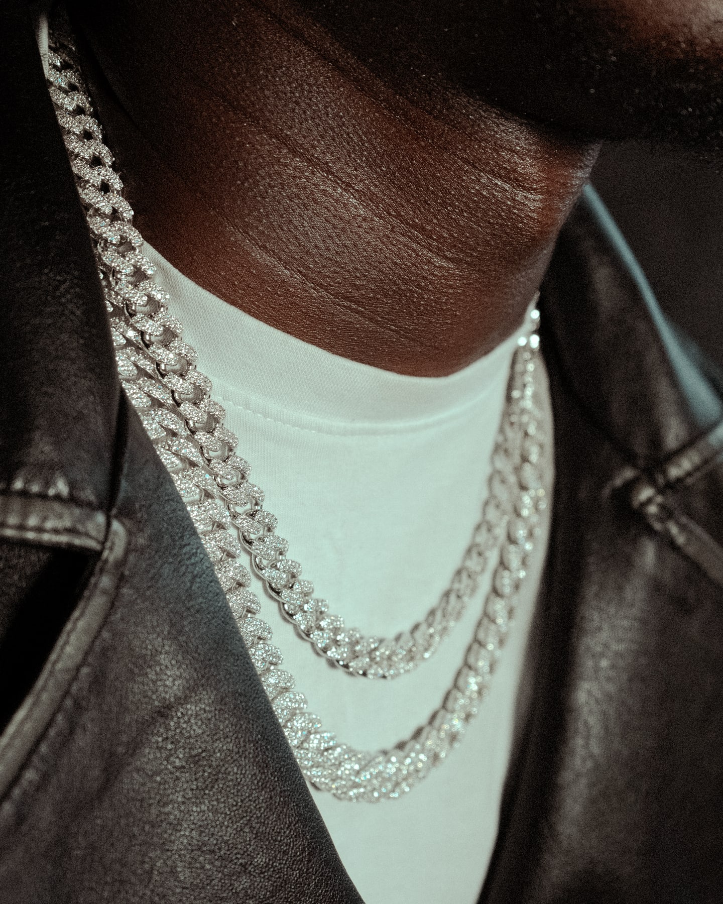 Close detail of layered jewelry and leather styling