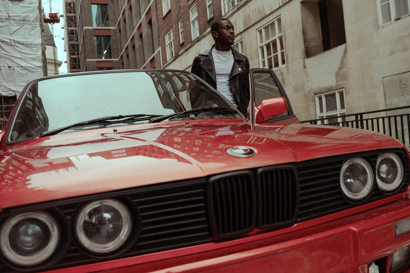 Fashion campaign still with model and red car